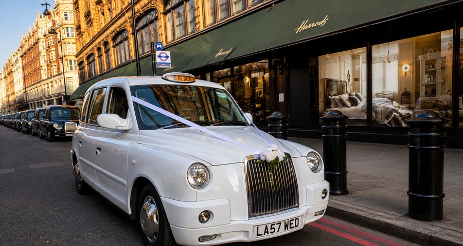 White TX4 wedding taxi outside Harrods in London