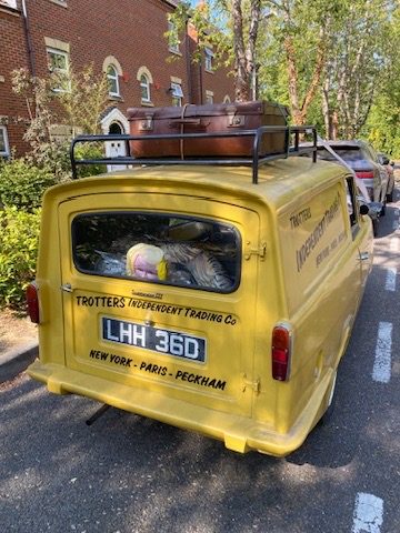 Rear of the Trotter van with vintage suitcases on the roof rack