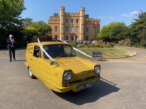 Del Boy Trotter van with ivory ribbons outside a castle wedding venue